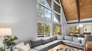 A modern living room with a large sectional sofa, a wooden coffee table, and a patterned rug.
