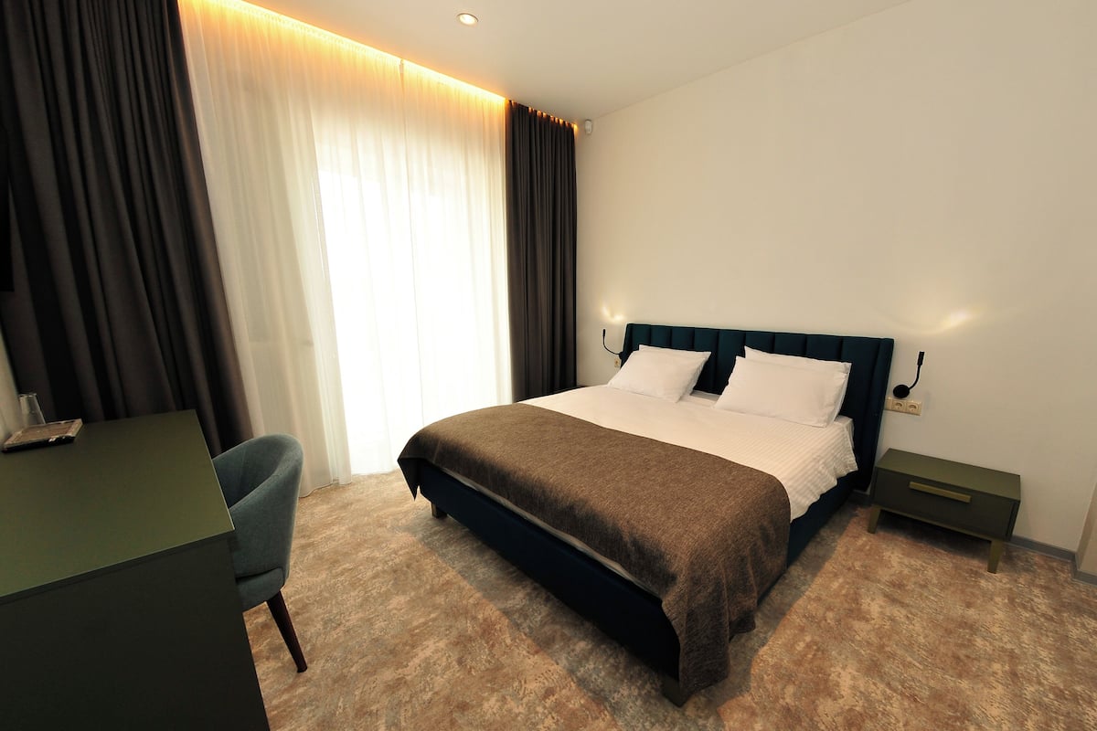 Ein Hotelzimmer mit einem Bett, einem Schreibtisch und einem Stuhl.