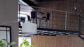 Una sala de estar moderna con un sofá color beige, un sillón azul y un tapete multicolor a rayas.