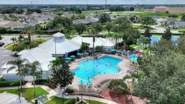 A residential area with a large swimming pool surrounded by palm trees and a gazebo. - Vacation Fantasia - Near Disney (Kissimmee)