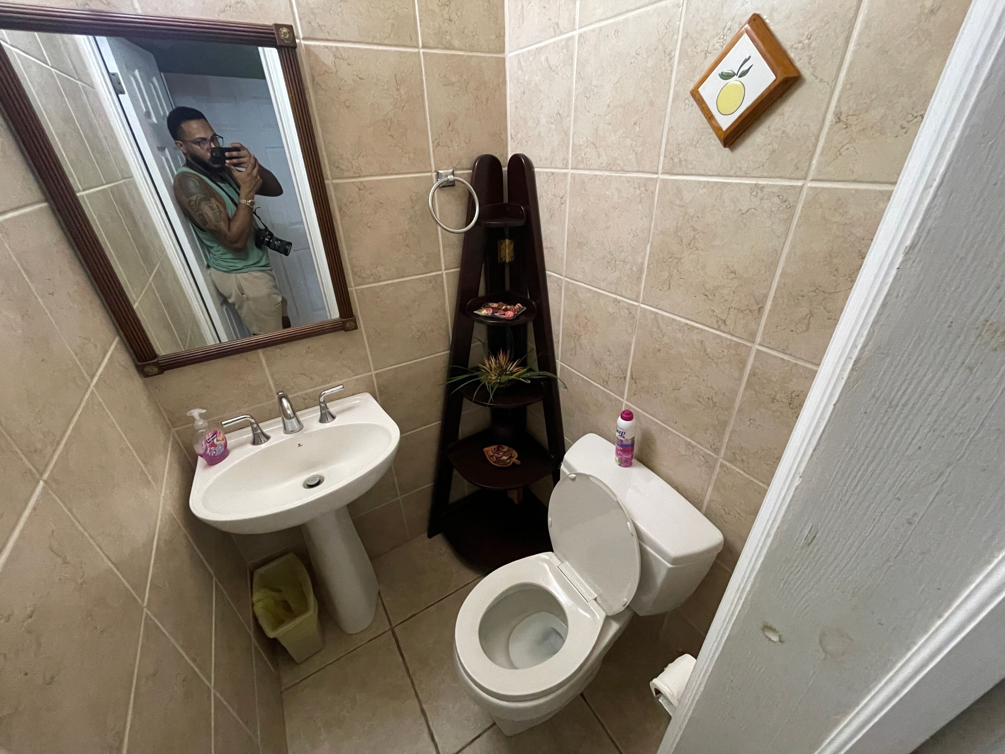 A bathroom with a sink, toilet, and a mirror.