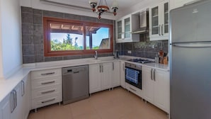 Een moderne keuken met witte kasten, een roestvrijstalen koelkast en een inbouwoven.