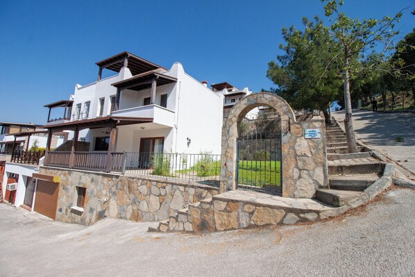 A two-story house with a stone entrance and a wooden balcony. - Villa Bambaska (Milas)