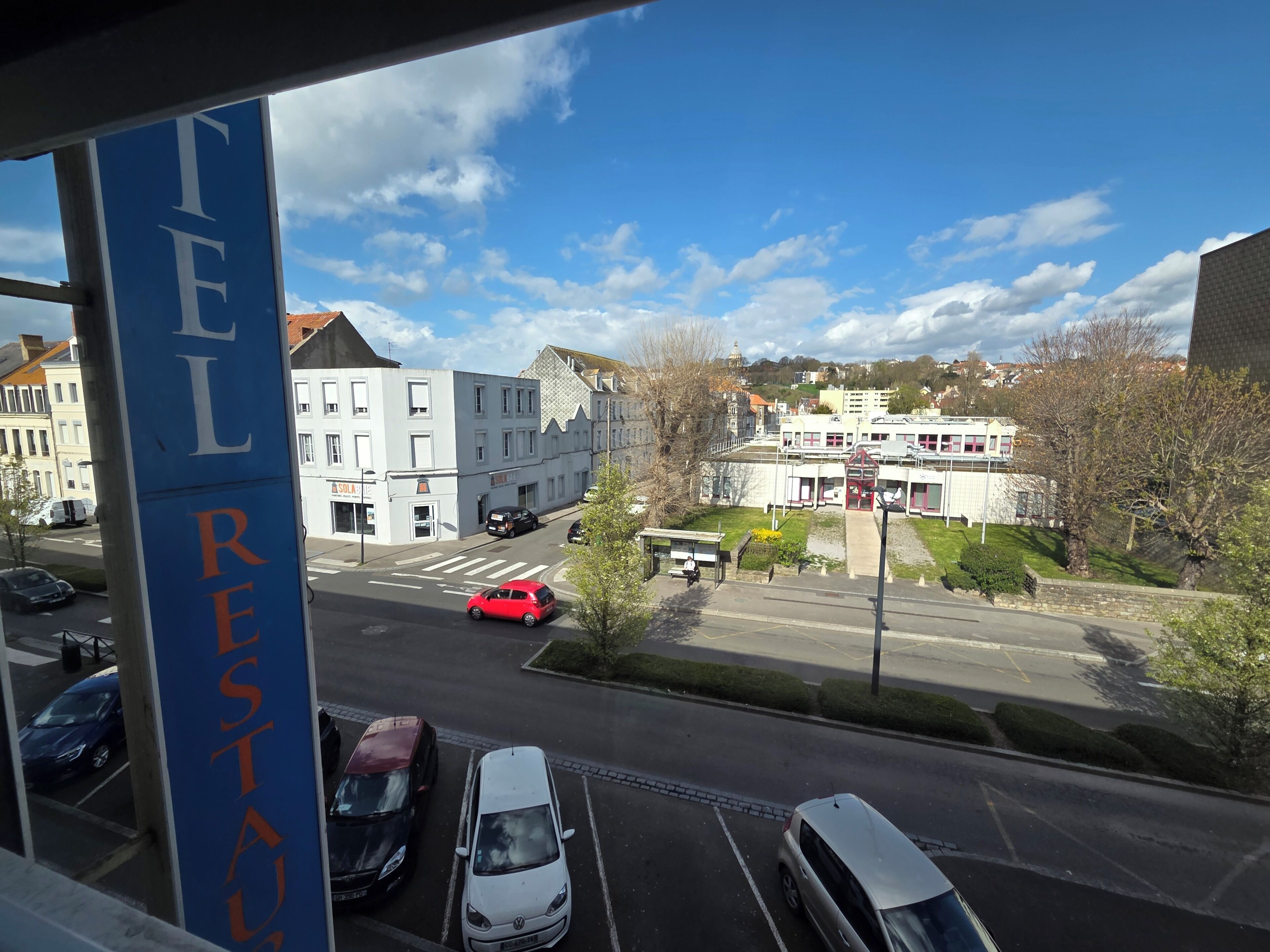 A street view with a building labeled 'FEL RESTAURANT' and parked cars.