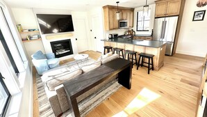 Une cuisine moderne avec des meubles en bois, un îlot central et des tabourets de bar.