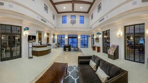 A spacious lobby with a reception desk, seating area, and large windows. - DLuxx Resort Villa w/ Pool & Lazy River 8965 (Kissimmee)