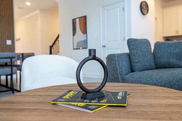 Una mesa de madera con una revista y un anillo negro.