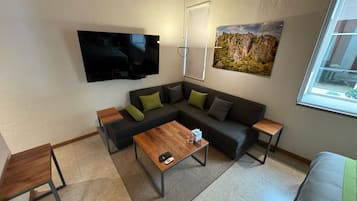 Habitación de lujo, vista al patio | Área de sala de estar | Televisión de 32 pulgadas con canales por cable