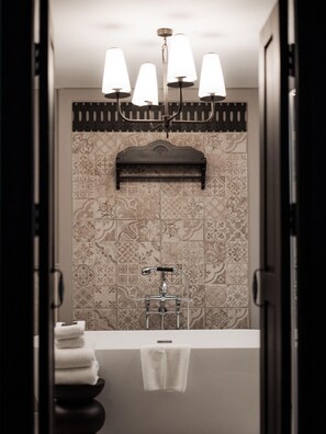 A bathroom with a bathtub, a towel rack, and a shower with a faucet. - Burirattana (Chiang Mai)