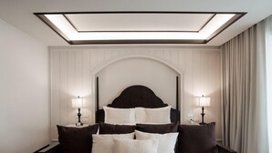 A modern hotel room with a large bed, bedside lamps, a dark coffee table, and a skylight above the bed. - Burirattana (Chiang Mai)
