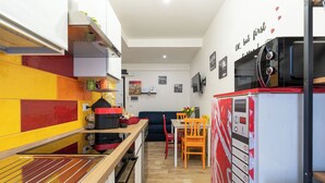 Eine kompakte Küche mit Mikrowelle, Kühlschrank und Essbereich mit Tisch und Stühlen.
