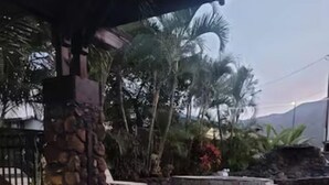 A stone patio with a pool, surrounded by tropical plants and a stone wall. - Robbins Estate (Wailuku)