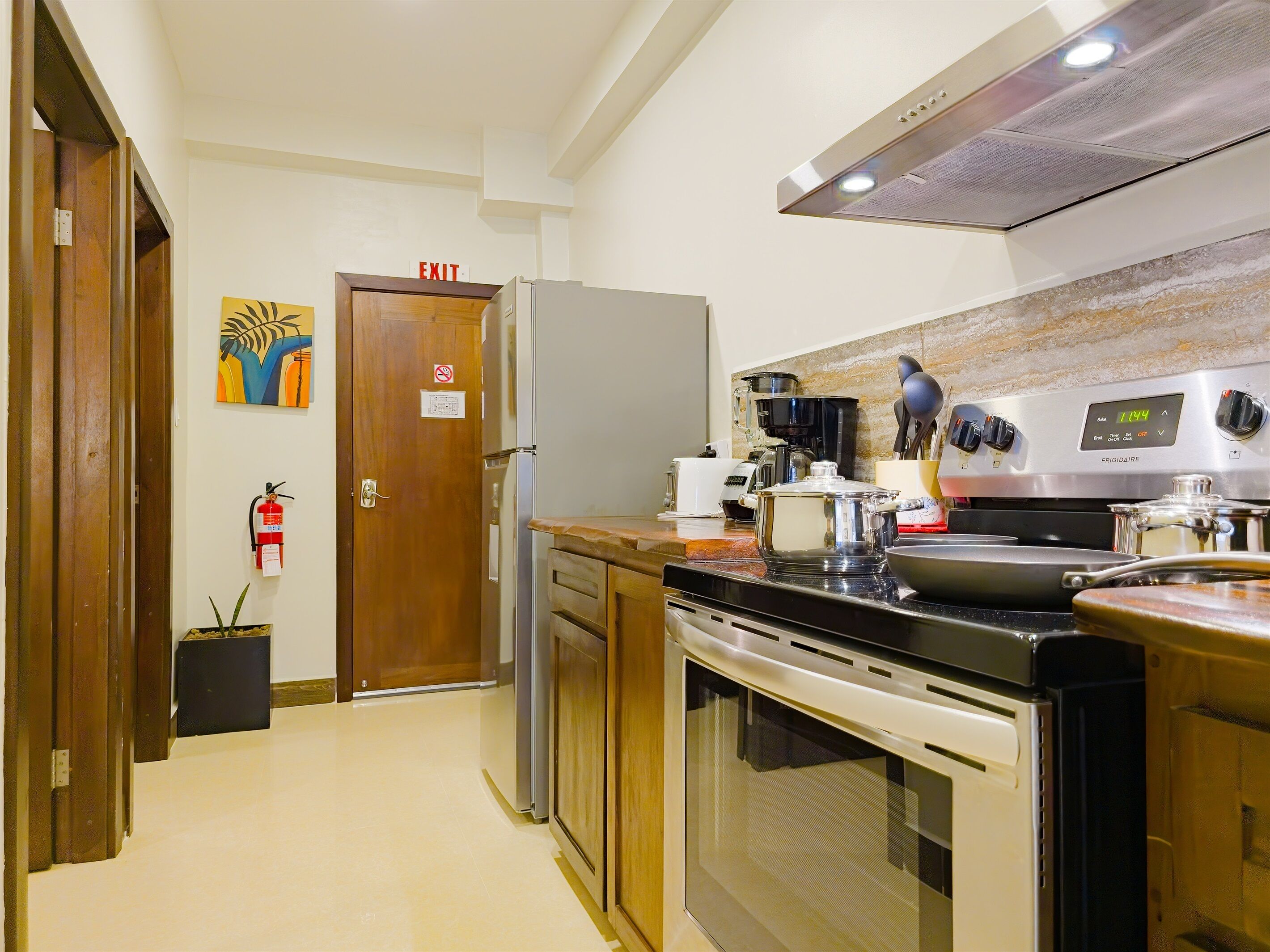 Eine Küche mit Kühlschrank, Herd, Mikrowelle und Kaffeemaschine.