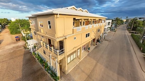A multi-story hotel with balconies, a parking area, and a street view. - F3 Apartment, 2-Bedroom (F3) (Placencia Village)
