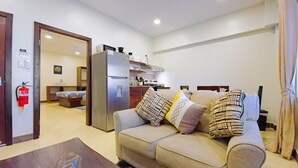 Una sala de estar moderna con un sofá, una mesa de centro y una cocina al fondo.