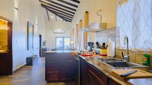 Een moderne keuken met een centraal eiland, ingebouwde apparatuur en een groot raam voor natuurlijk licht.