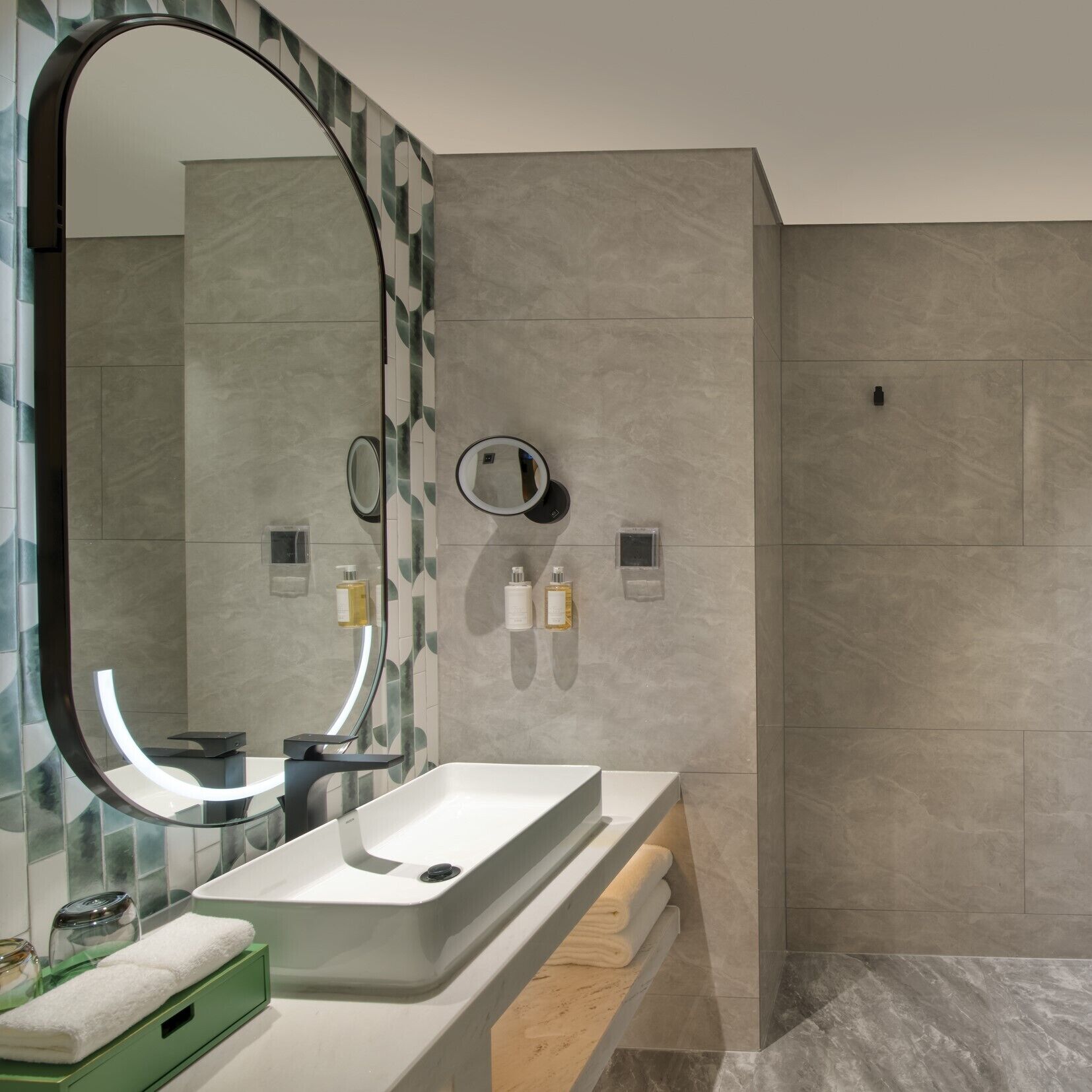 Een moderne badkamer met een grote spiegel, een rechthoekig wastafelmeubel en een douchecabine van glas.