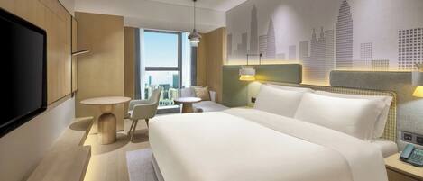 Ein modernes Hotelzimmer mit einem großen Bett, einem Fernseher, einem Schreibtisch und Blick auf die Stadt.