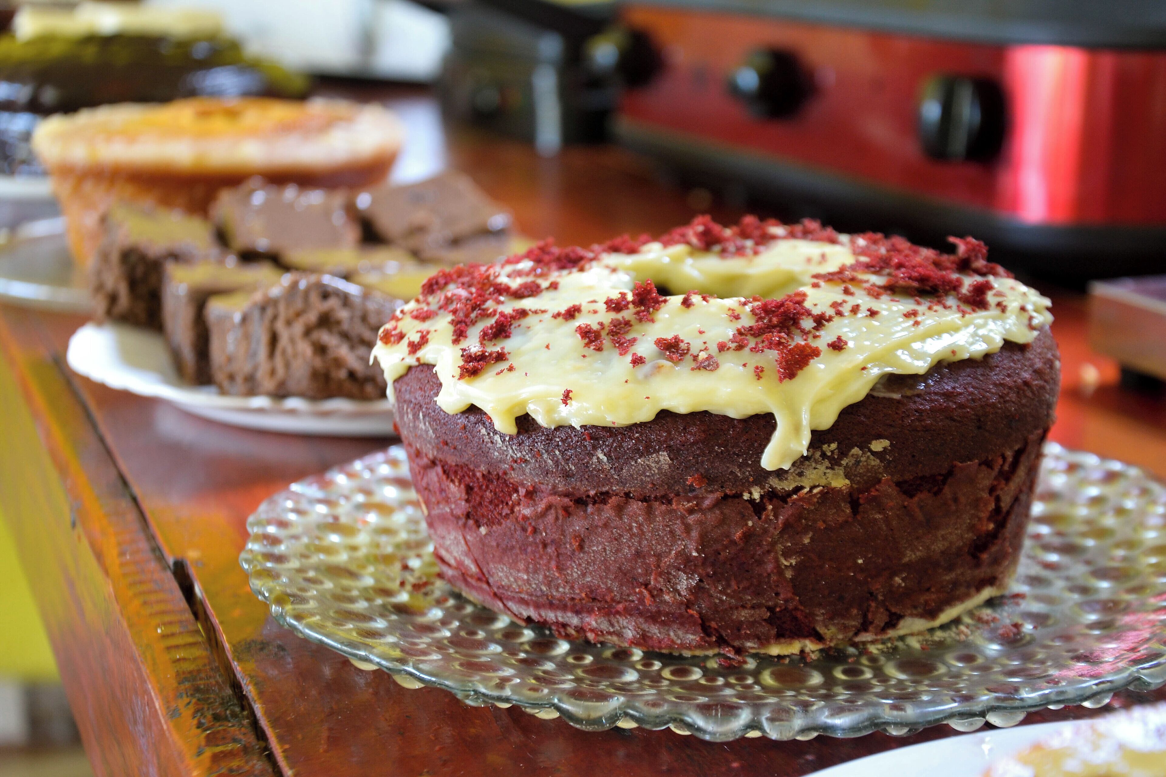 A dessert on a glass plate with a cake in the background.