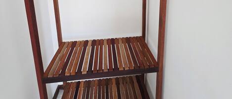 Una scaffalatura in legno a più ripiani con un gancio metallico.