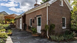 Ein Ziegelhaus mit einer überdachten Veranda, einer Haustür und einem kleinen Fenster.
