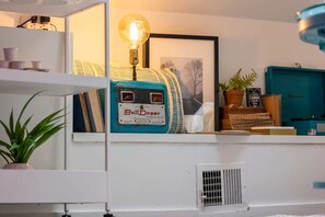 Een kamer met een vintage radio, een ingelijst beeld, een potplant en een blauwe kast.