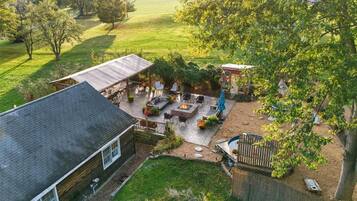 A backyard with a patio, outdoor seating, a fire pit, and a small shed.