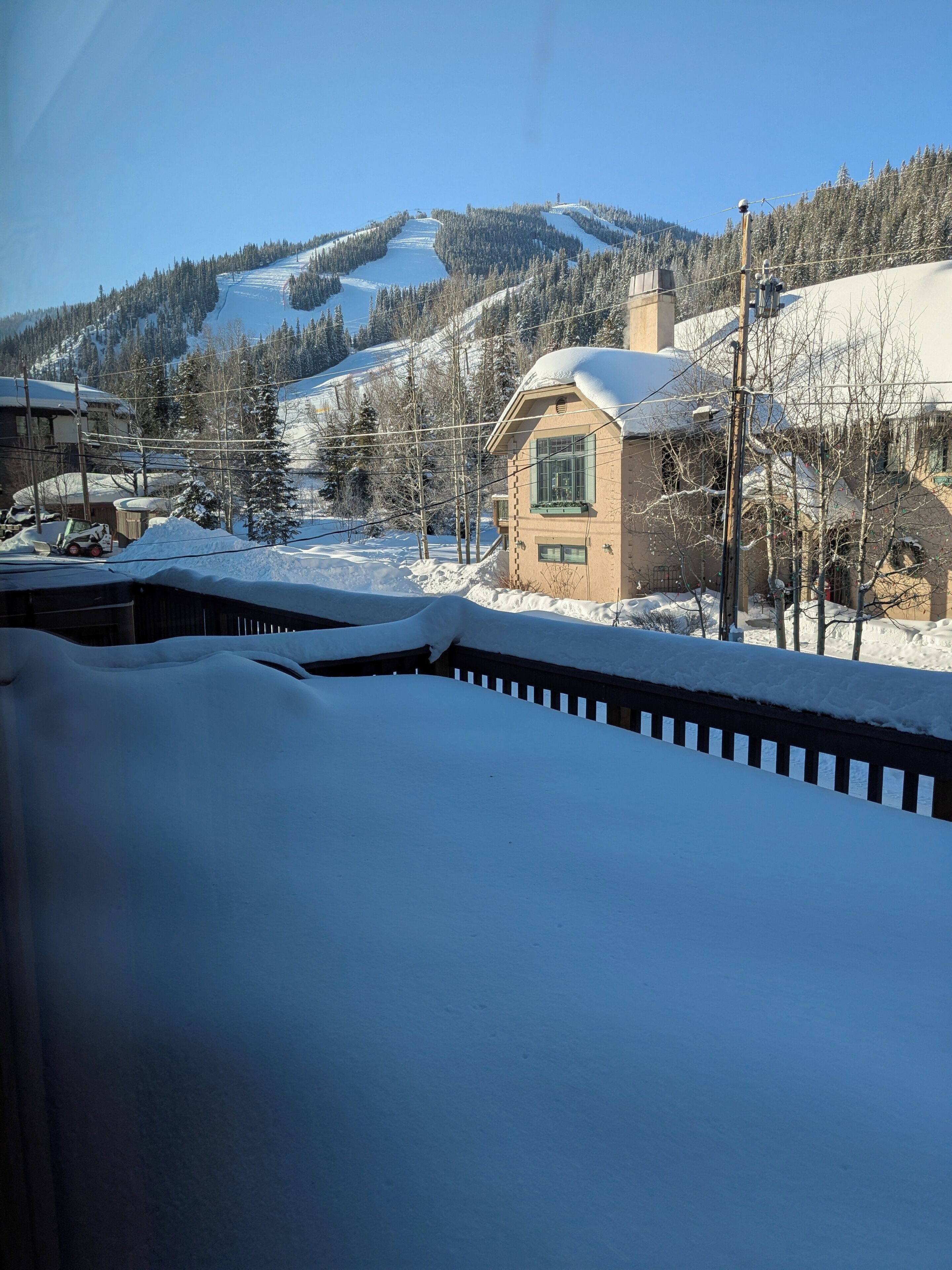 A snow-covered landscape with a small building and a mountain in the background.