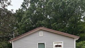 A single-story house with a front door, a small window, and a chimney.