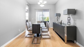 Un espace repas moderne avec une table ronde, des chaises et une console intégrée agrémentée de lampes.