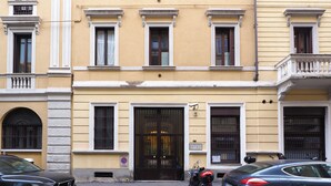 A yellow building with a black door, windows with shutters, and a balcony. - C23 - Premium Apartment in Milan (Milano)