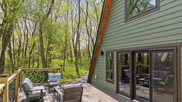 A deck with outdoor furniture, a wooden fence, and a view of a forest. - Brand NEW build. A-frame 2bed+/2bath. Nature paradise. Pepin, WI. (Pepin)