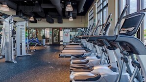 Et fitnesscenter med løbebånd, træningsmaskiner og skilt med henvisning til massage.