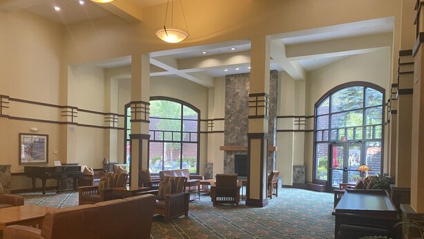 A spacious lobby with a grand piano, comfortable seating, and large windows offering views of the outdoors. - The ultimate resort experience. Pool, hot tub, sauna, steam room, exercise room. (Hunter)