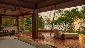 A spacious room with a large bed, a seating area with a view of the sea, and a balcony with wooden flooring and outdoor furniture. - Naviva, A Four Seasons Resort, Punta Mita, Mexico - All Inclusive (Punta de Mita)