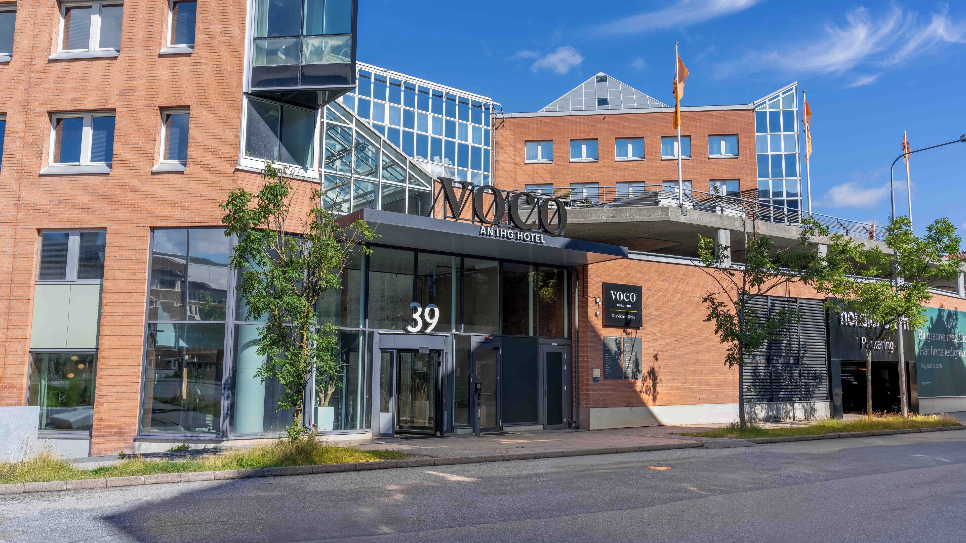 A modern hotel with a glass facade, numbered 39, and a staircase leading to an upper level.