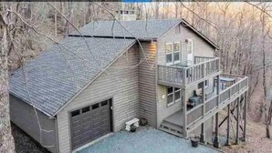 Une maison à deux étages avec un garage, un balcon et un petit porche.