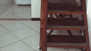 A kitchen with wooden cabinets, a white refrigerator, and a wooden ladder leaning against the wall. - Flats Paraty (Patitiba Paraty)