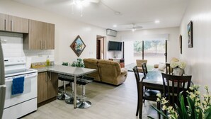 A modern kitchen with a dining area, a sofa, and a TV. - Apartamento Ganesha Liberia (Liberia)