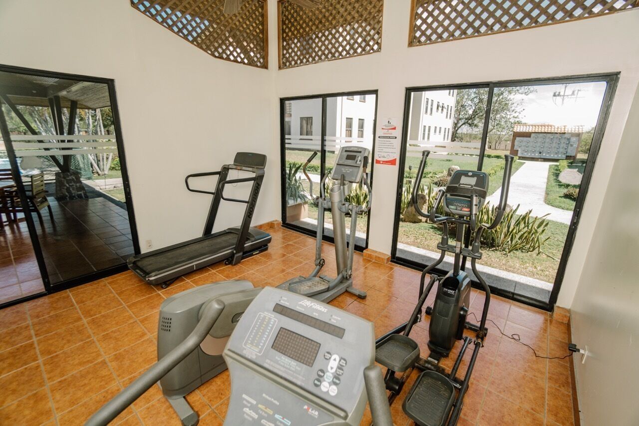 A gym with treadmills, an elliptical, and a stationary bike.