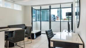 A modern office space with a glass wall, a round table, and two chairs.