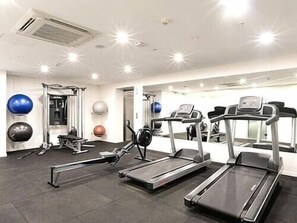 A gym with treadmills, exercise balls, and weight machines.