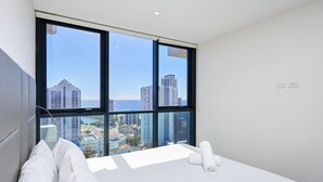 A modern hotel room with a large window offering a city view. - Bright Open view 2 bedroom Apartment in Gold Coast (Surfers Paradise)