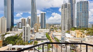 A high-rise cityscape with modern buildings, a clear sky, and a view of the street below. - Comfy 2 Double-bed Hotel Room Next to BeachandTram (Surfers Paradise)