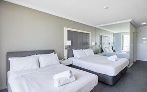 Escritorio, tabla de planchar con plancha y ropa de cama 