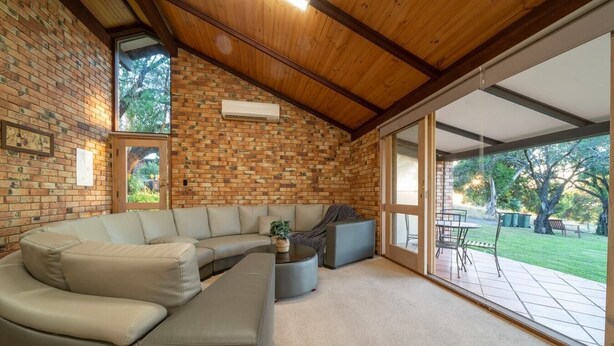A modern living room with a sectional sofa, a coffee table, and a fireplace.