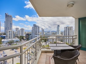 Enjoy the city view from this balcony with a table and two chairs.