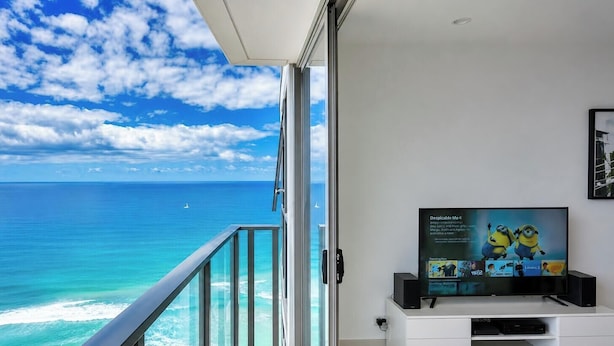 Ein Balkon mit Glasgeländer und Blick auf den Ozean.