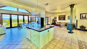 A spacious kitchen with a large island, a built-in stove, and a view of the outdoors. - Condor Estate Spacious with Vineyard and Fireplace (Maslin Beach)