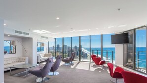 A modern lounge with a city view, large windows, and contemporary seating.